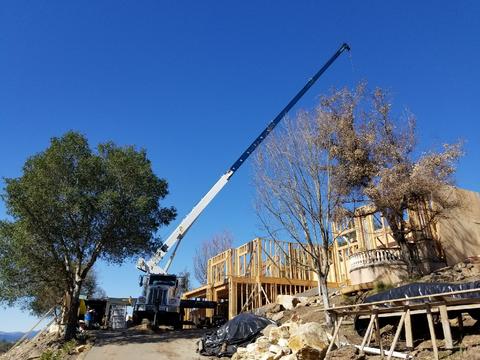 Setting beams at a residential construction job with our 30-ton boom truck.