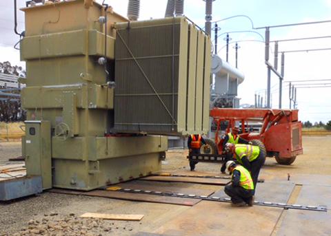 A hydraulic skidding system moves a large transformer into position at an electric substation where a crane can't fit
